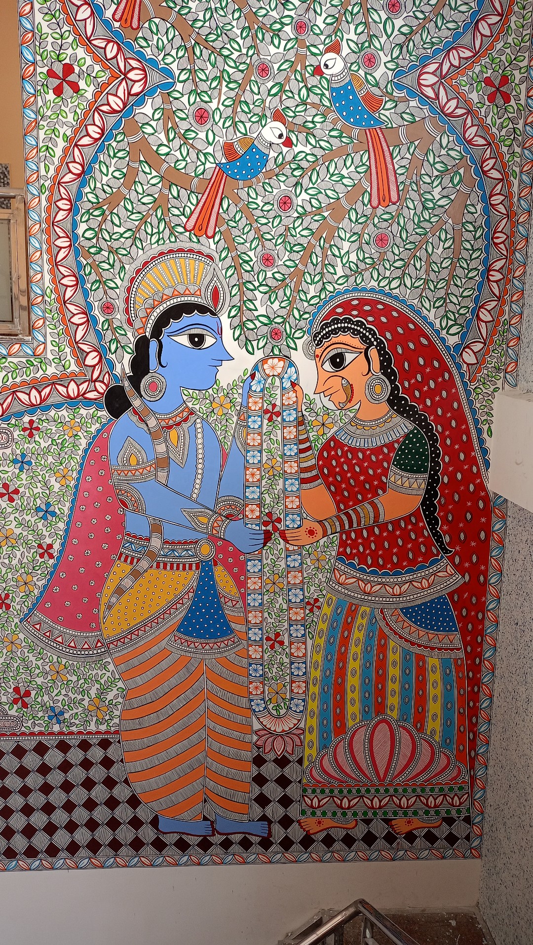 Ram and Sita's garland exchange, painted floor-to-ceiling on a stairway wall